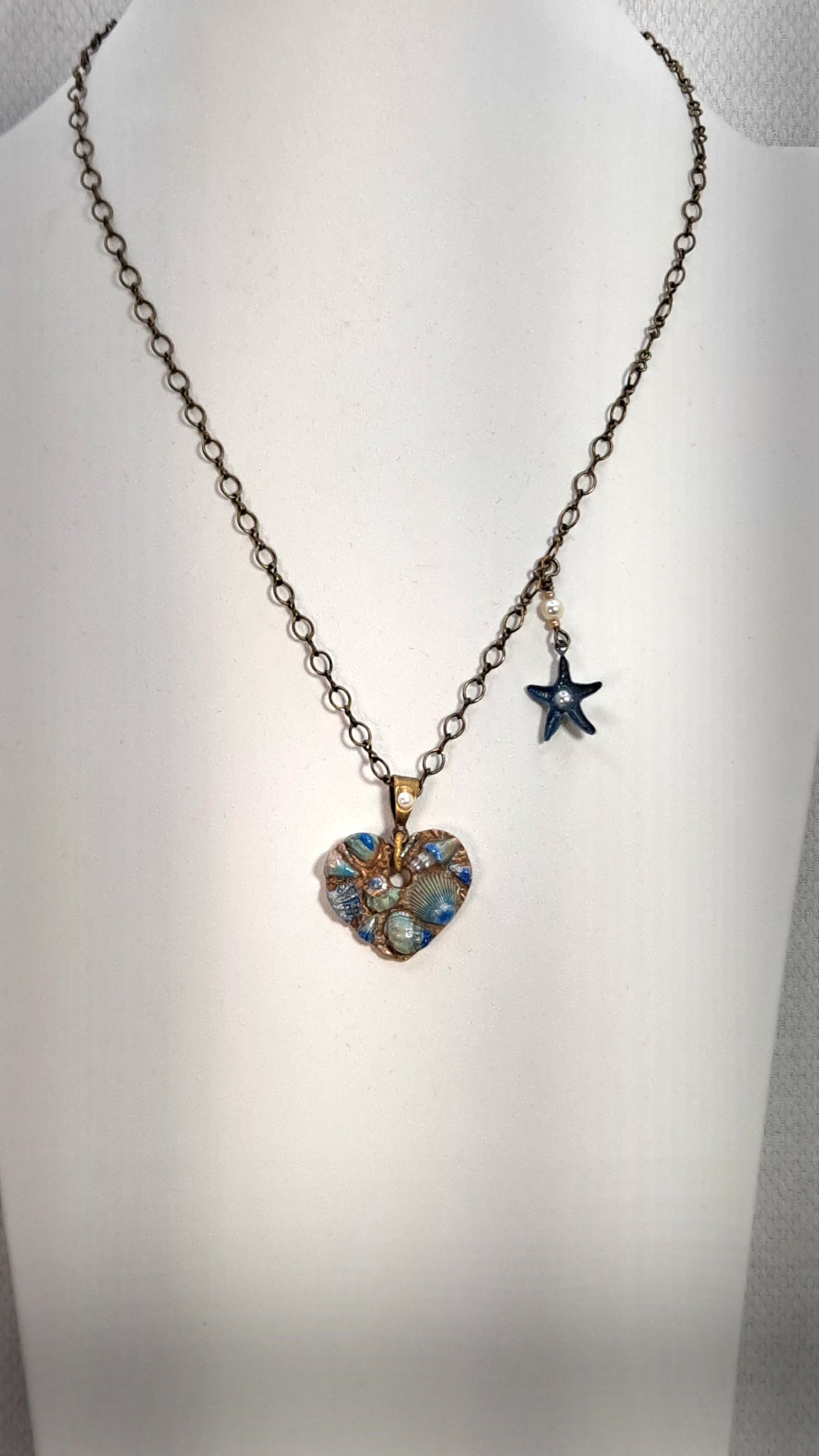 Necklace of Gold metal clay molded to a heart with sea Shells and hand painted.