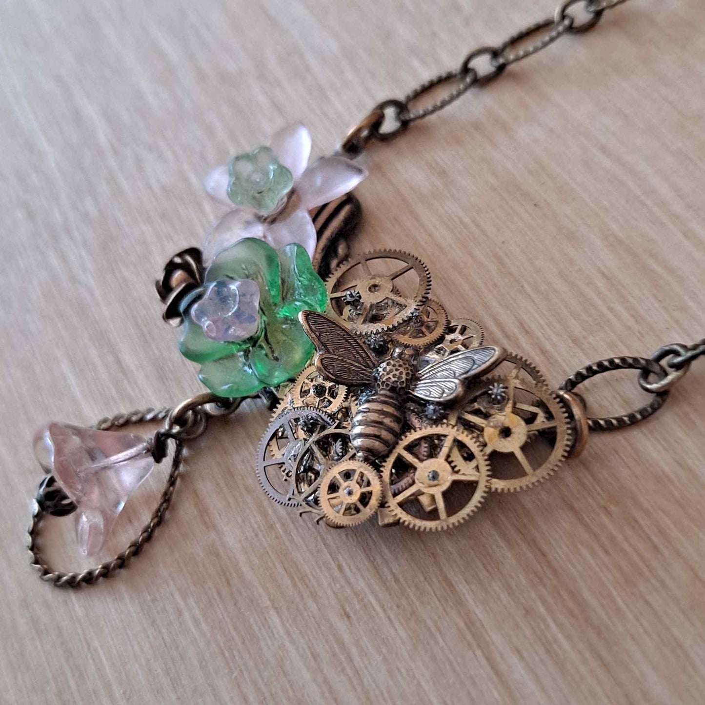 Brass collage necklace with vintage watch parts and green & pink Lucite flowers