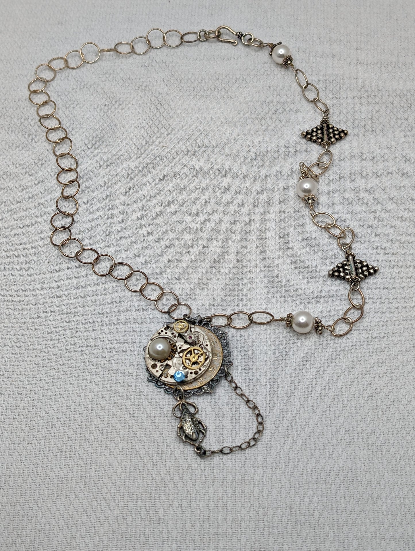 Sterling Silver necklace with vintage watch parts, pearls, blue crystal and scarab charm