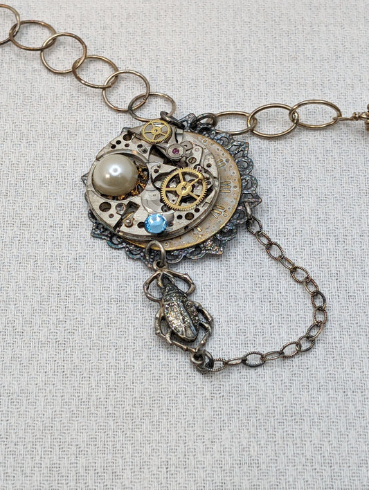 Sterling Silver necklace with vintage watch parts, pearls, blue crystal and scarab charm