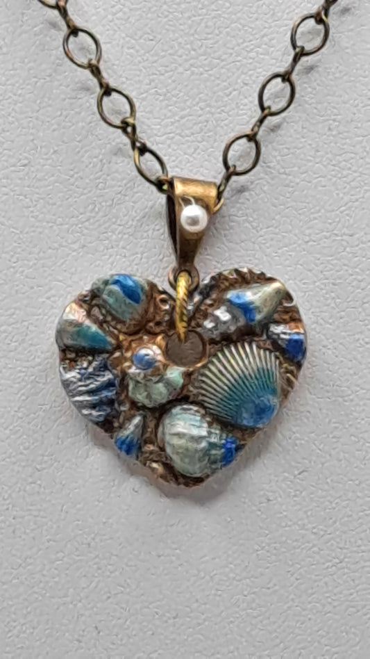 Necklace of Gold metal clay molded to a heart with sea Shells and hand painted.