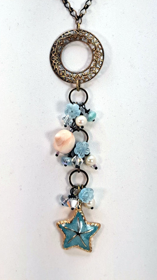 Brass filigree necklace accented with shells, pearls, glass beads, blue starfish.