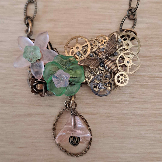 Brass collage necklace with vintage watch parts and green & pink Lucite flowers
